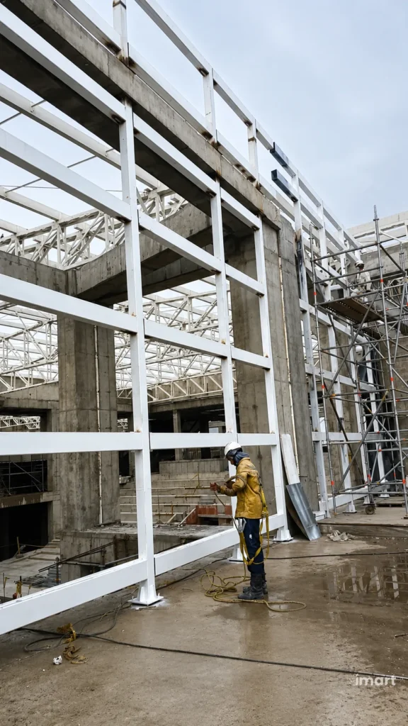 Instalación de la estructura metálica de fachada, con anclajes a los muros de concreto.