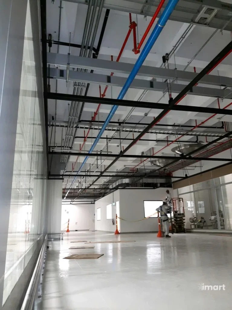 Pasillo t&eacute;cnico con bandejas portacables y tuber&iacute;as rojas y azules
